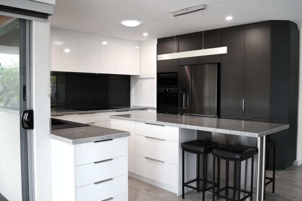 a kitchen with black cabinets and white countertops