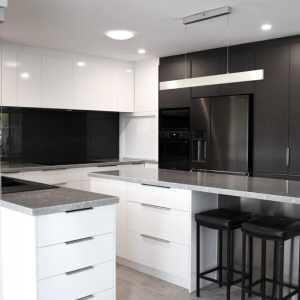 a kitchen with black cabinets and white countertops