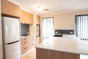 Double galley kitchen renovation with timber cabinetry, white stone benchtop and black sink tap by Kitchens Perth